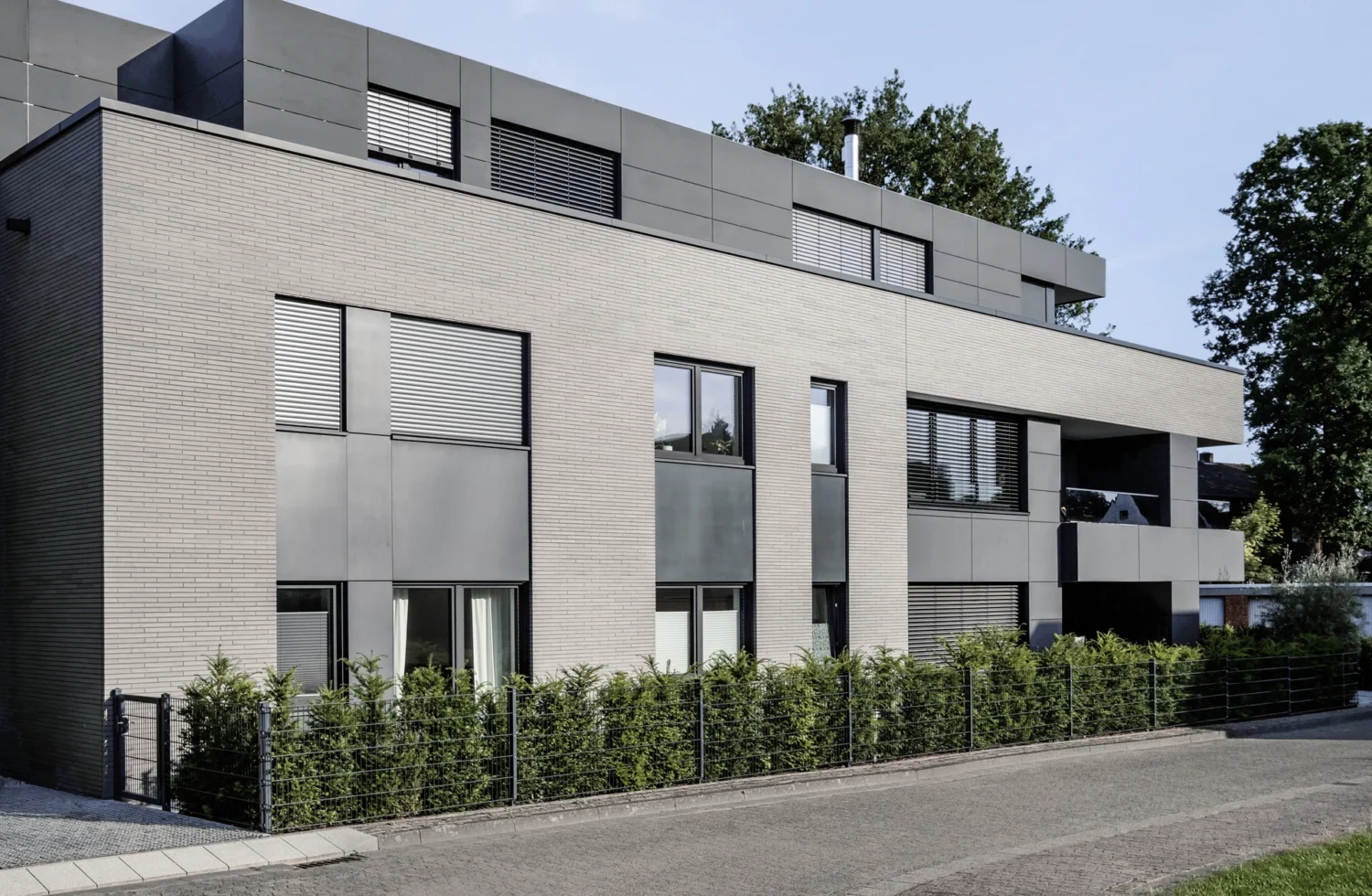 Moderne Wohnarchitektur mit grauen Fassaden und großen Fenstern